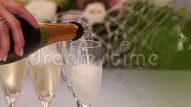 在户外餐厅的庆祝活动中，服务员向酒杯倒香槟。 生日派对中闪烁的白色哀鸣